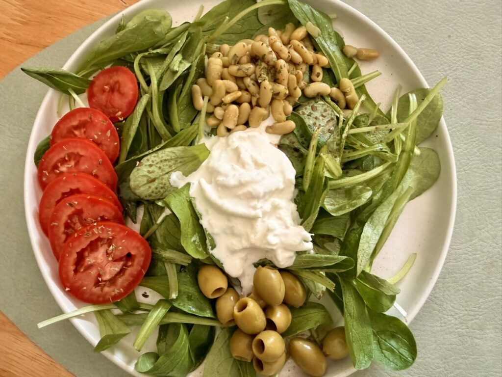 Mache, green olives, flageolets, stracciatella, and tomato salad